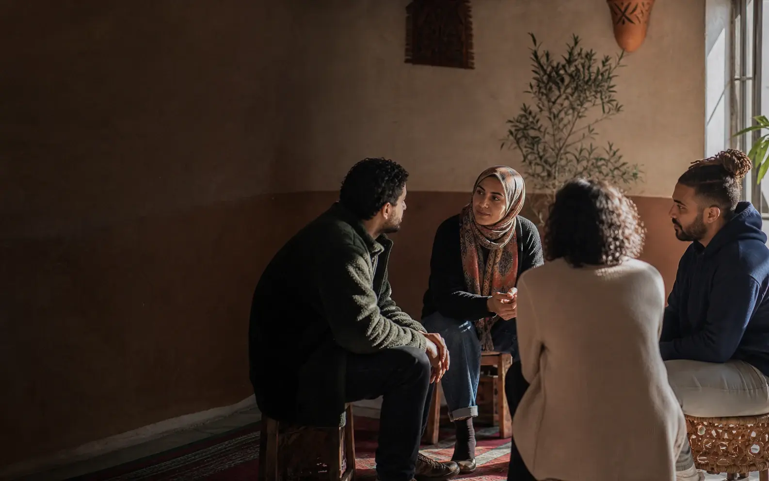 Four community members listening to one another in a calm circle