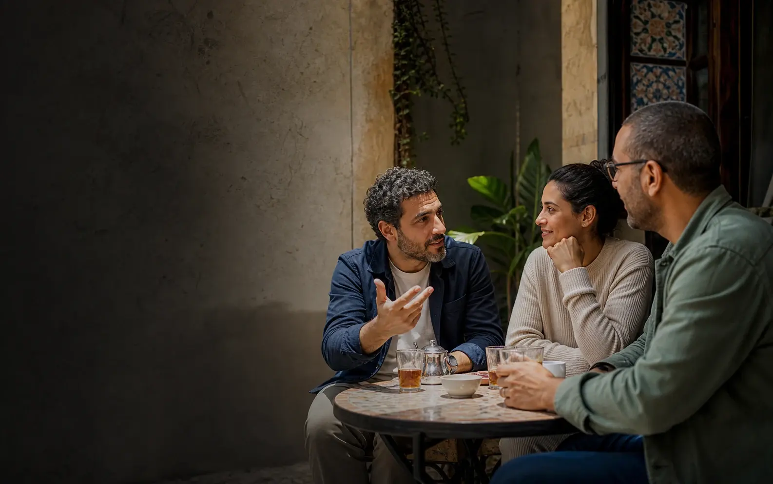 Three community members sharing questions and answers at a neighborhood table